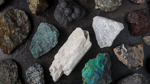 Mixture of critical minerals shot overhead on a slate background.