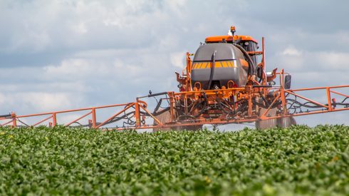 Machine spraying fertilizer in soybean plantation